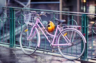 lyserød gammel cykel med cykelhjelm