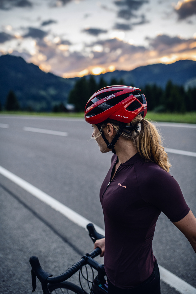 Billedet viser en kvindelig cyklist med en racerhjelm.