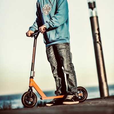 Billedet viser en dreng der står med sit trickløbehjul i en skaterpark.