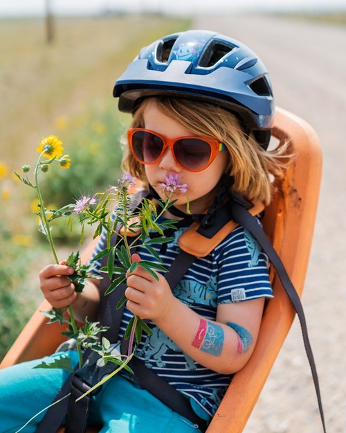 Barn bærer cykelhjelm i cykelstol