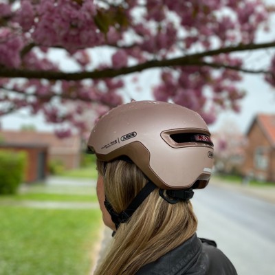 Billedet er et livsstilsbillede og viser en kvinde der bærer en Abus cykelhjelm.