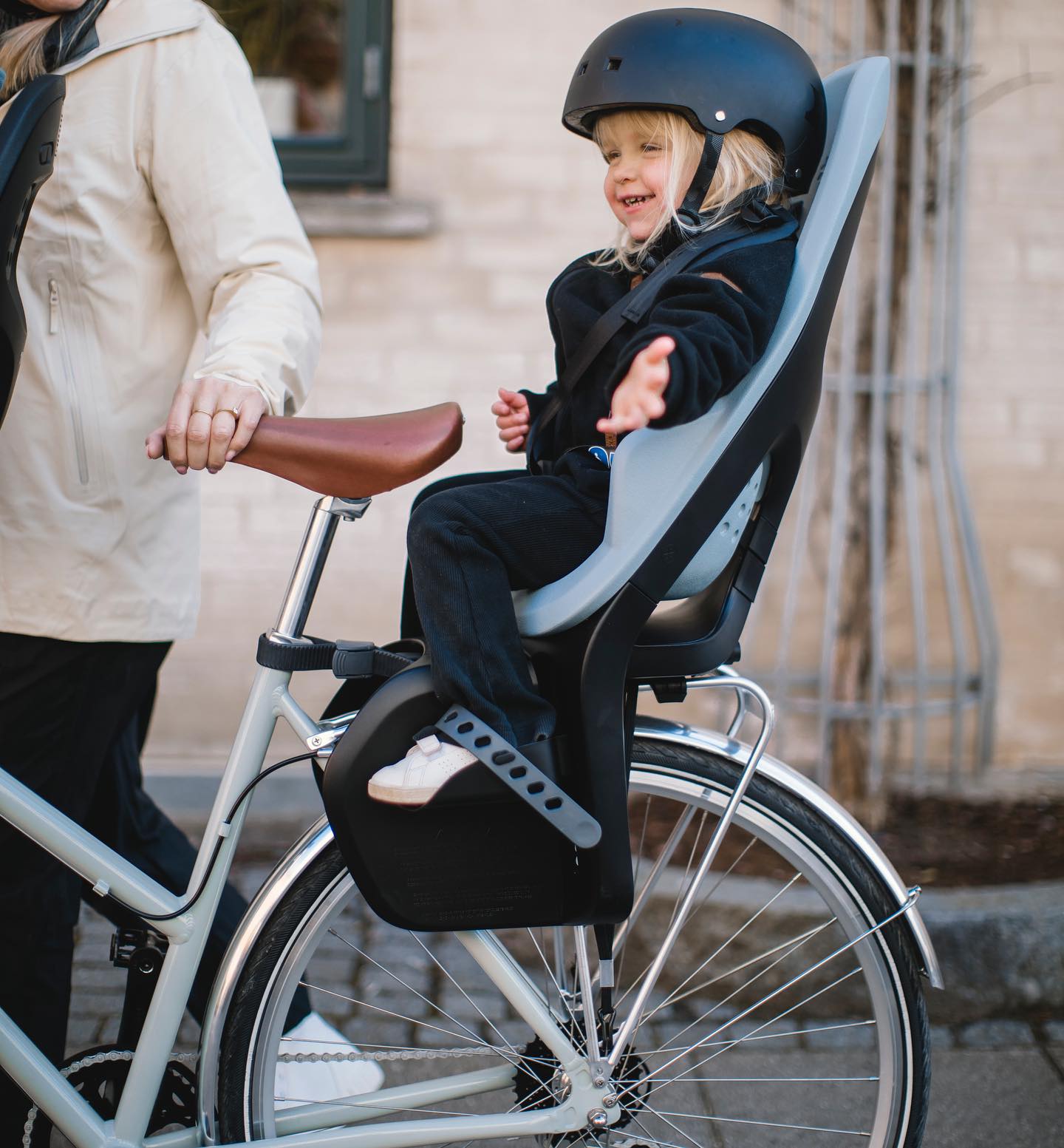 billedet viser en glad dreng der sidder i en cykelstol og nyder omgivelserne.